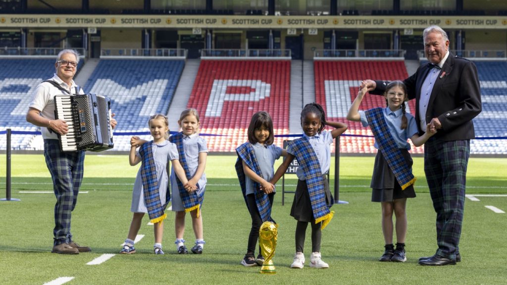 Former Scotland keeper Alan Rough with pupils from Croftfoot Primary School and RSCDS Music Director Ian T. Muir pose for photos in Hampden to launch World Cup Dance Day